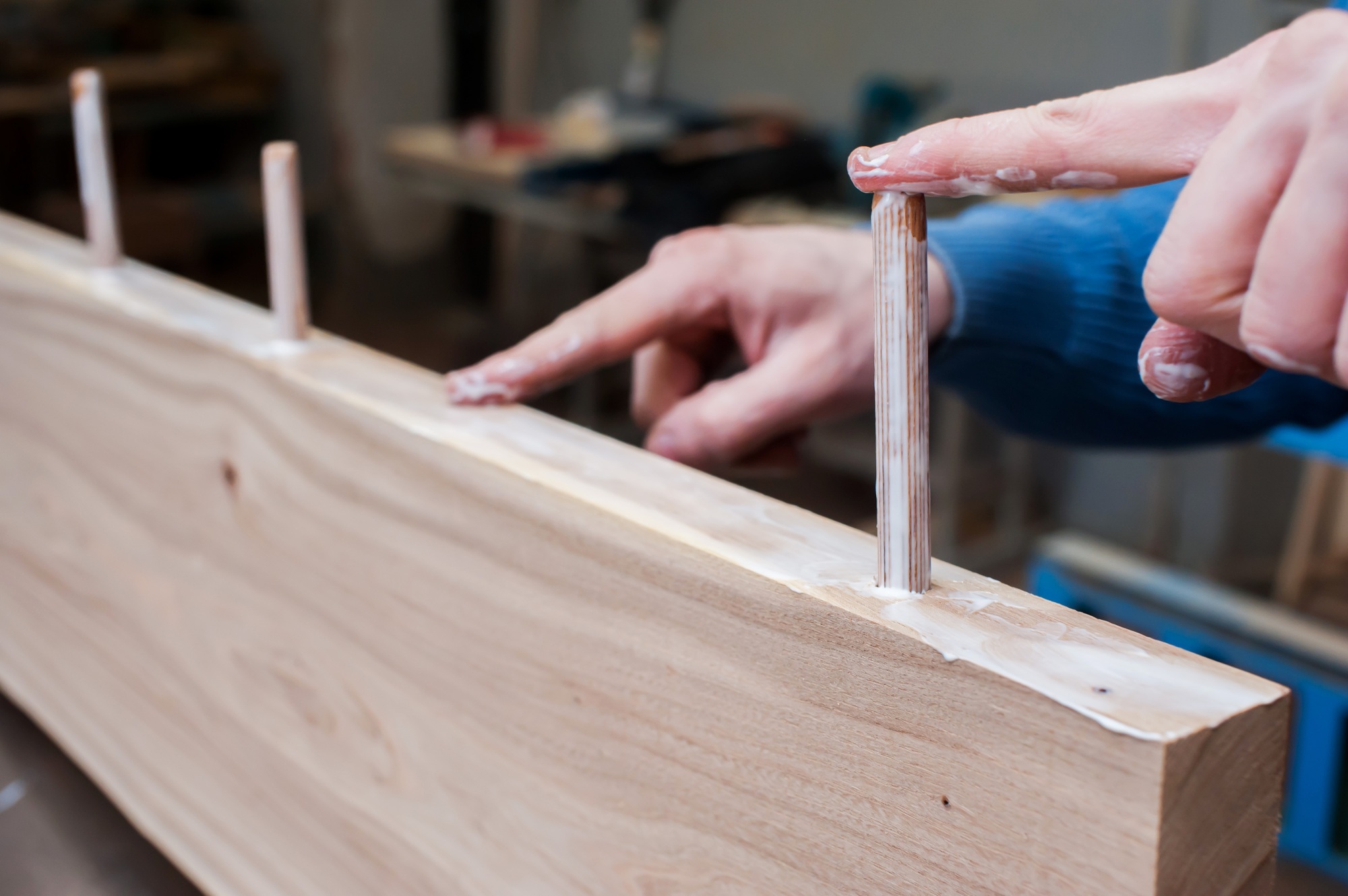 Gluing wood onto wooden dowels in a carpentry workshop. Furniture manufacturing